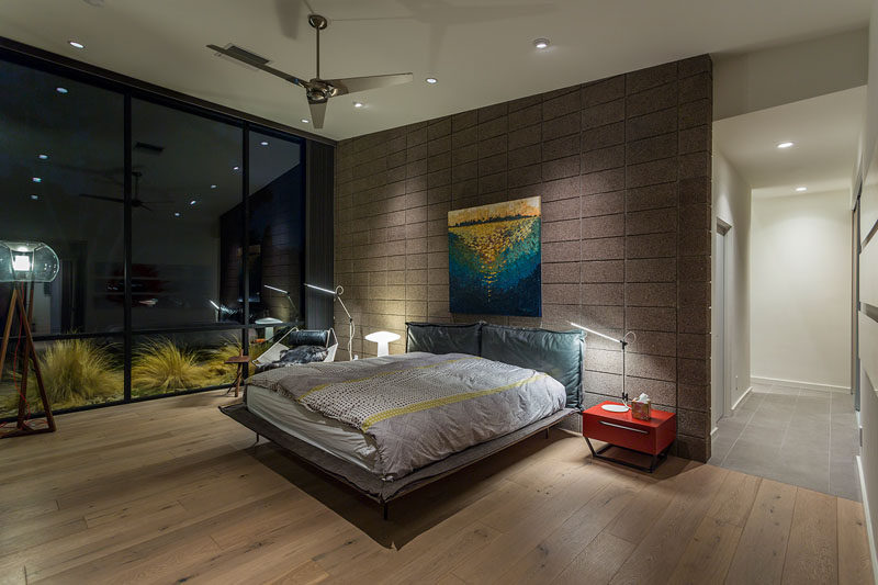 This modern master bedroom opens to the exterior, while the blockwork creates an accent wall for the master bed and flows from inside to out. #ModernMasterBedroom #Windows #BedroomDesign