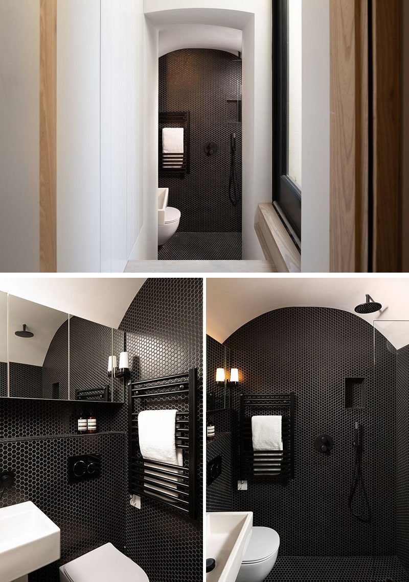 In this modern bathroom, black penny tiles cover the walls and floor, creating a bold and striking color contrast. #BlackBathroom #BlackPennyTiles