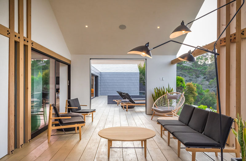 A covered area of this deck has been designated as a secondary living space, with armchairs, sofas, and lighting. #OutdoorSpace #OutdoorLivingRoom