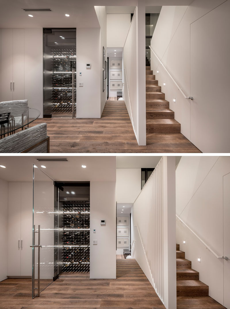 Featured throughout this modern house are a wide plank, long dimension engineered wood floors, that help to create a seamless appearance. A wine room with a pivoting glass door is located next to a closet and bathroom. #WoodFlooring #WineRoom #WineStorage