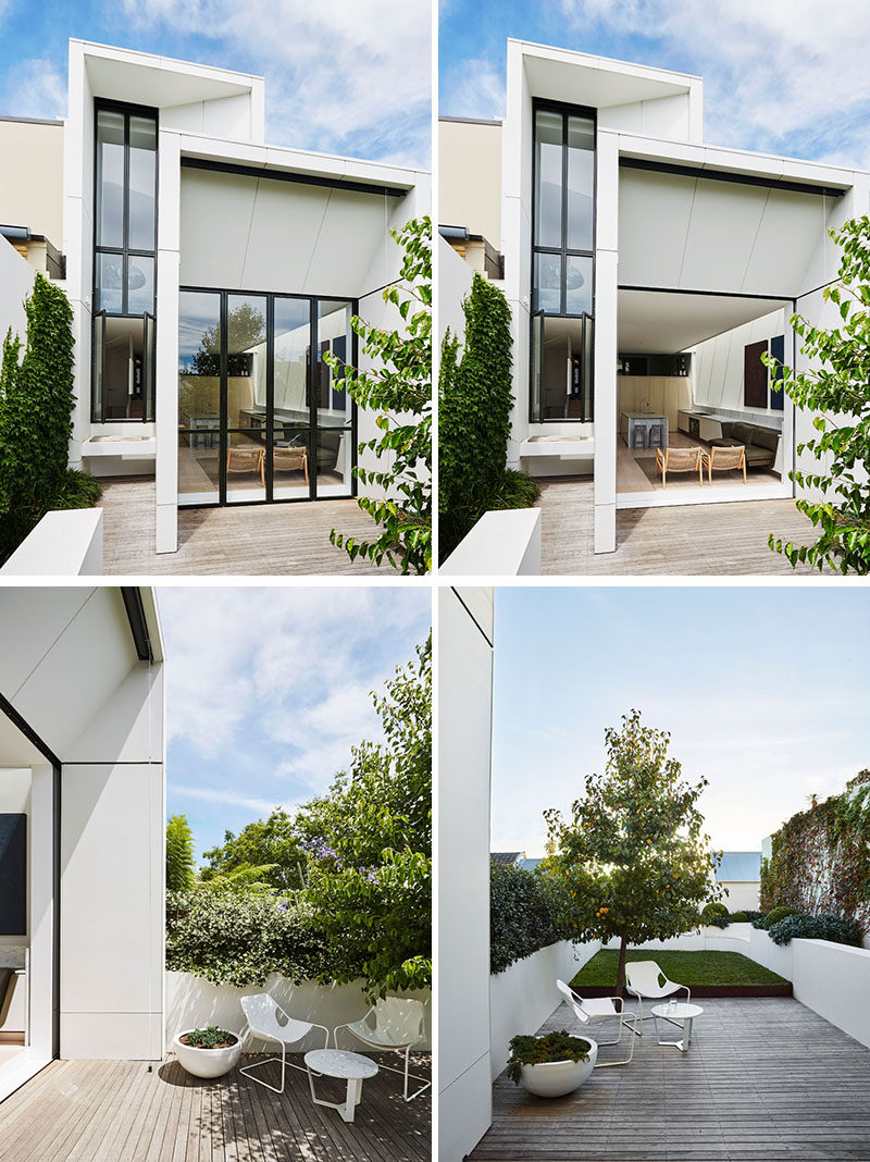 The modern extension features bi-fold pocket doors that hide away and open up the interior space to the terrace and grassed area beyond. #ModernExtension #Architecture #Landscaping #Backyard