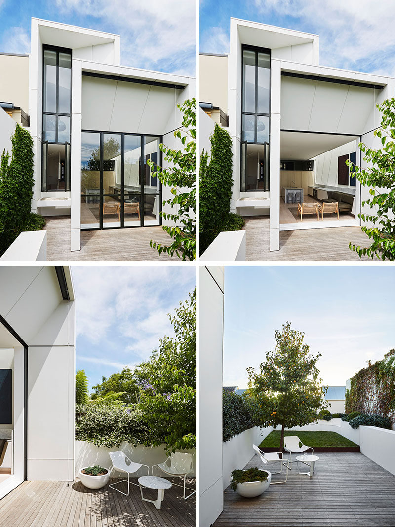 The modern extension features bi-fold pocket doors that hide away and open up the interior space to the terrace and grassed area beyond. #ModernExtension #Architecture #Landscaping #Backyard