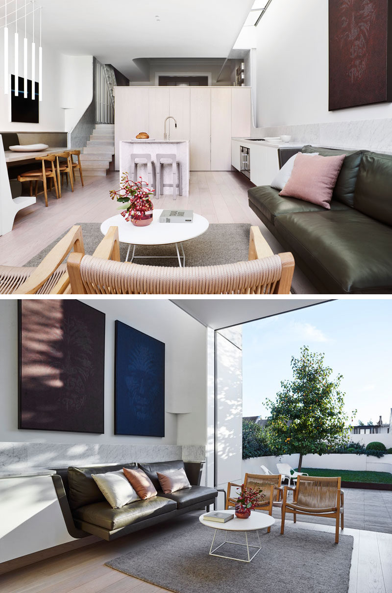 The open floor plan of this modern house extension allows for a casual living room with a built-in couch, the kitchen, and a dining area. #LivingRoom #OpenPlanInterior #ModernInteriorDesign