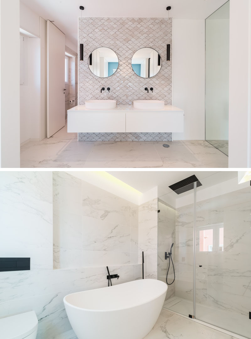 In this modern master bathroom, a decorative fish-scale tile pattern highlights the vanity, while on the opposite wall, a freestanding bathtub is the focal point. #MasterBathroom #ModernBathroom