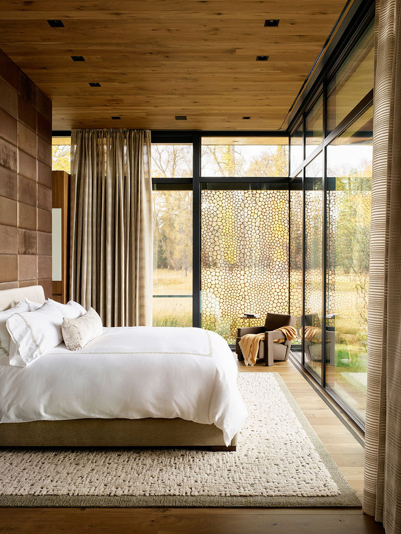 This modern bedroom features floor-to-ceiling windows, creating a private nature experience. #ModernBedroom #BedroomDesign