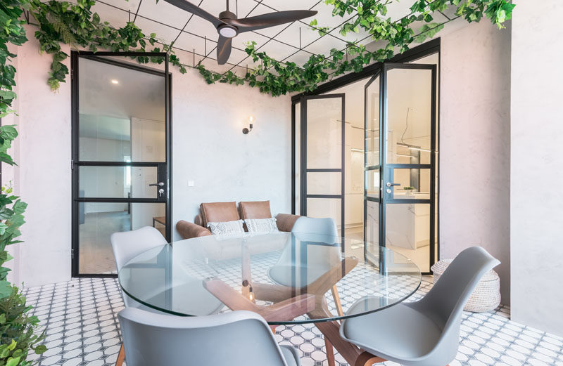 This modern apartment has a winter garden, with a sitting area, a dining area, and plants that will grow to create a green ceiling. #SittingArea #InteriorDesign