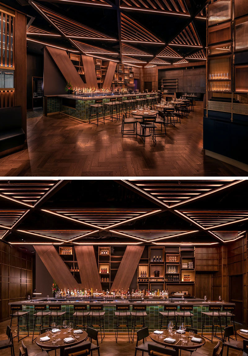 The trellis’ alternating patterns of open and slatted triangular surfaces in this restaurant, help to conceal the acoustical and lighting systems, while also acting as a unifying element that draws guests into the heart of the interior. #RestaurantDesign #BarDesign #RestaurantCeiling