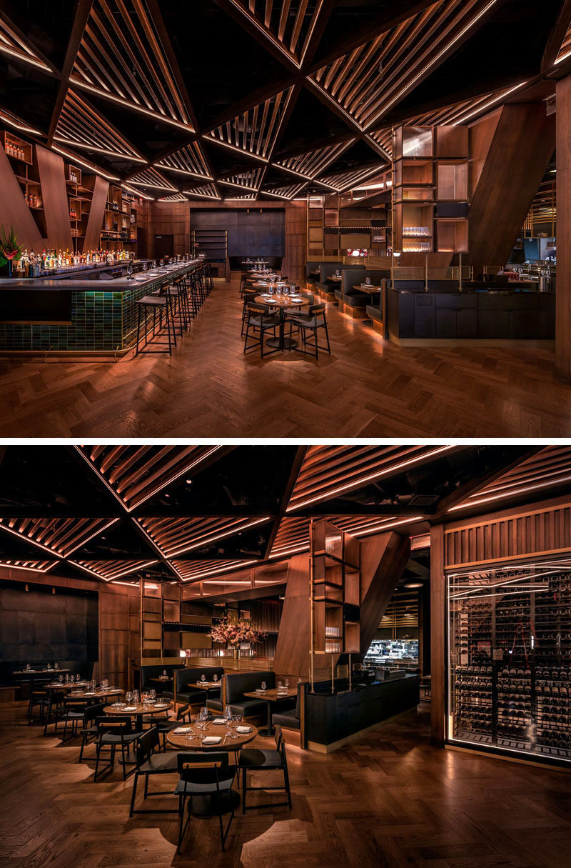 This modern restaurant's distinctive and massive structural joists divide the bar area from the main dining room. These angled columns& inspired the bar’s geometrical millwork and its triangular patterned wood trellis ceiling. #RestaurantDesign #ModernRestaurant #RestaurantInterior