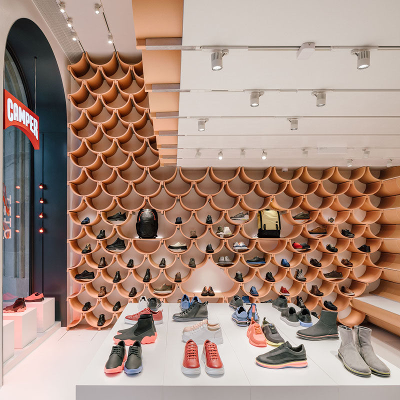 Inside, the pattern on the walls is revealed to be made up of roof-tile like ceramic elements, that neatly complement each other. #RetailStoreDesign #InteriorDesign #RetailDesign