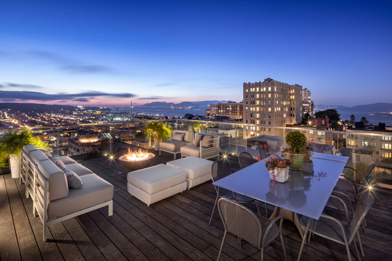 This modern rooftop deck has a lounge area with a fireplace, and a dedicated area for alfresco dining. #RooftopDeck