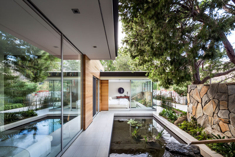 This modern house has a water feature that can be enjoyed from one of the bedrooms. #WaterFeature #ModernPond #LandscapeDesign #Landscaping