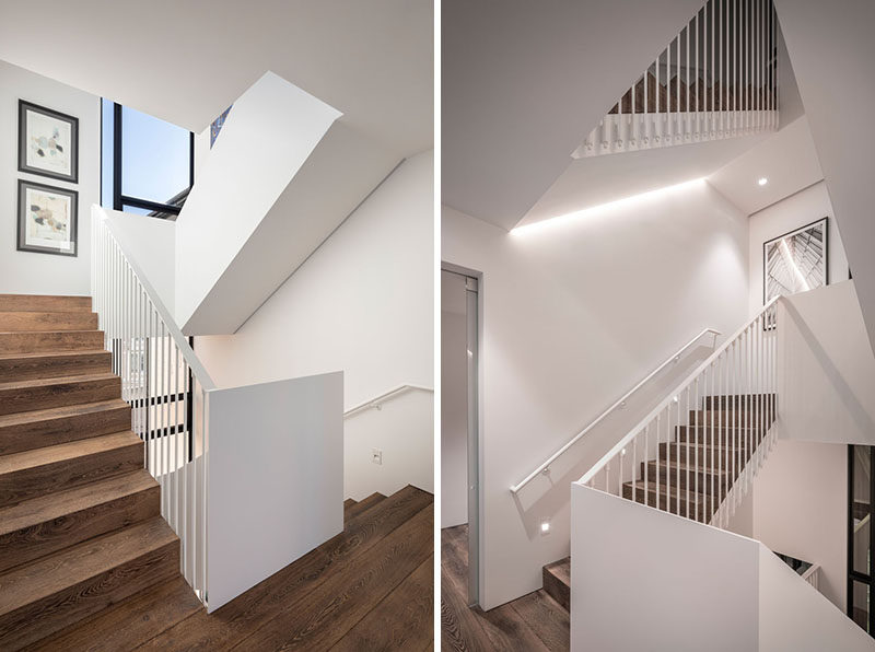 Connecting all of the floors throughout this modern four storey house, is a bright white staircase with wood stairs and hidden lighting. #WhiteStaircase #WoodStairs #StairLighting