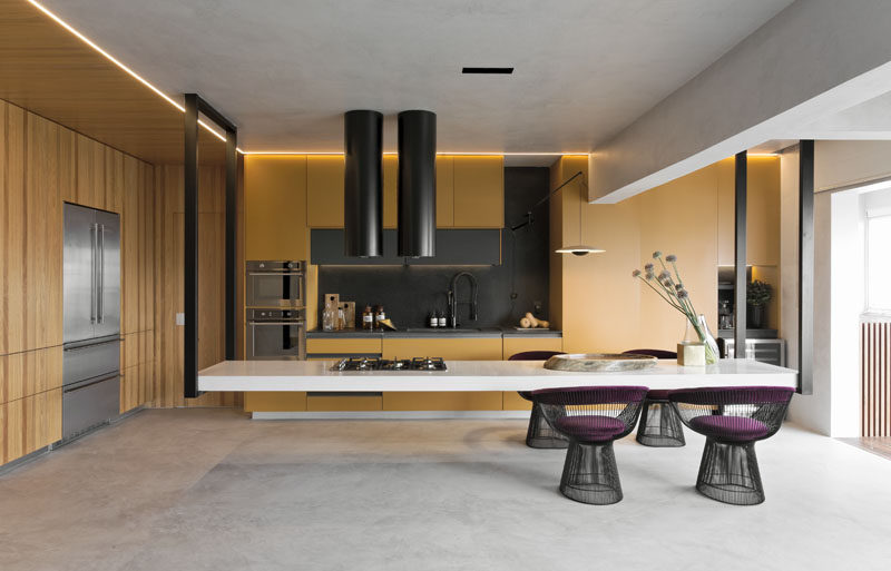 This modern kitchen features an eye-catching hanging island, that measures in at 14 feet (4.5m) long, and is suspended at its ends by black metal supports. #HangingIsland #KitchenDesign #ModernKitchen