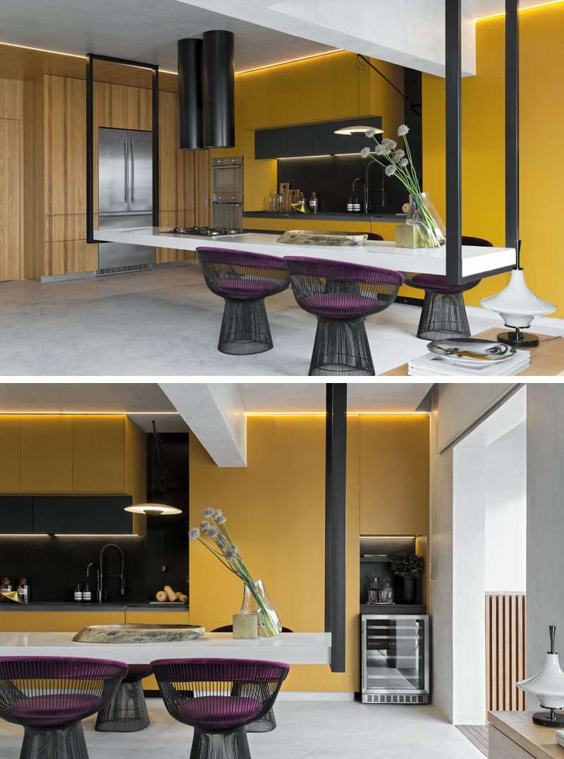 This modern kitchen features an eye-catching hanging island, that measures in at 14 feet (4.5m) long, and is suspended at its ends by black metal supports. #HangingIsland #KitchenDesign #ModernKitchen