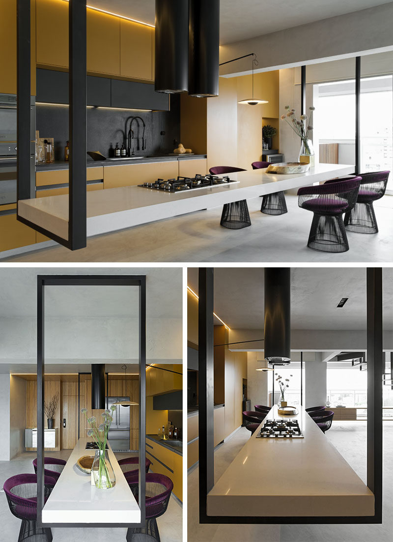 This modern kitchen features an eye-catching hanging island, that measures in at 14 feet (4.5m) long, and is suspended at its ends by black metal supports. #HangingIsland #KitchenDesign #ModernKitchen