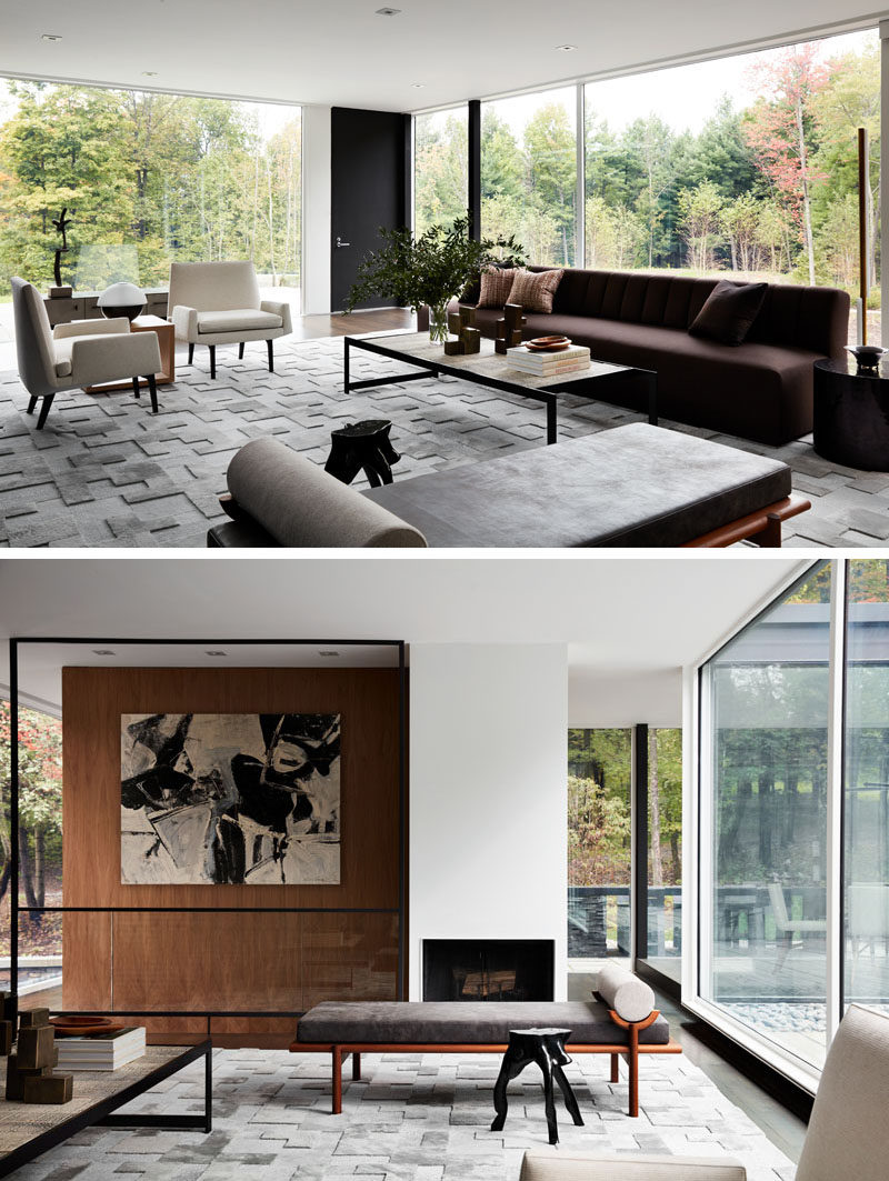 In this modern living room with glass walls, a variety of seating options are arranged to take advantage of the different views on offer. #LivingRoom #ModernInterior #Fireplace