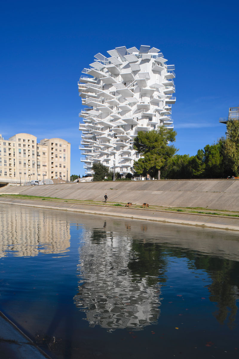 This modern apartment building in France has cantilevered balconies that surround it, while stairs connect the various outdoor spaces. #ModernArchitecture #BuildingDesign #Balconies