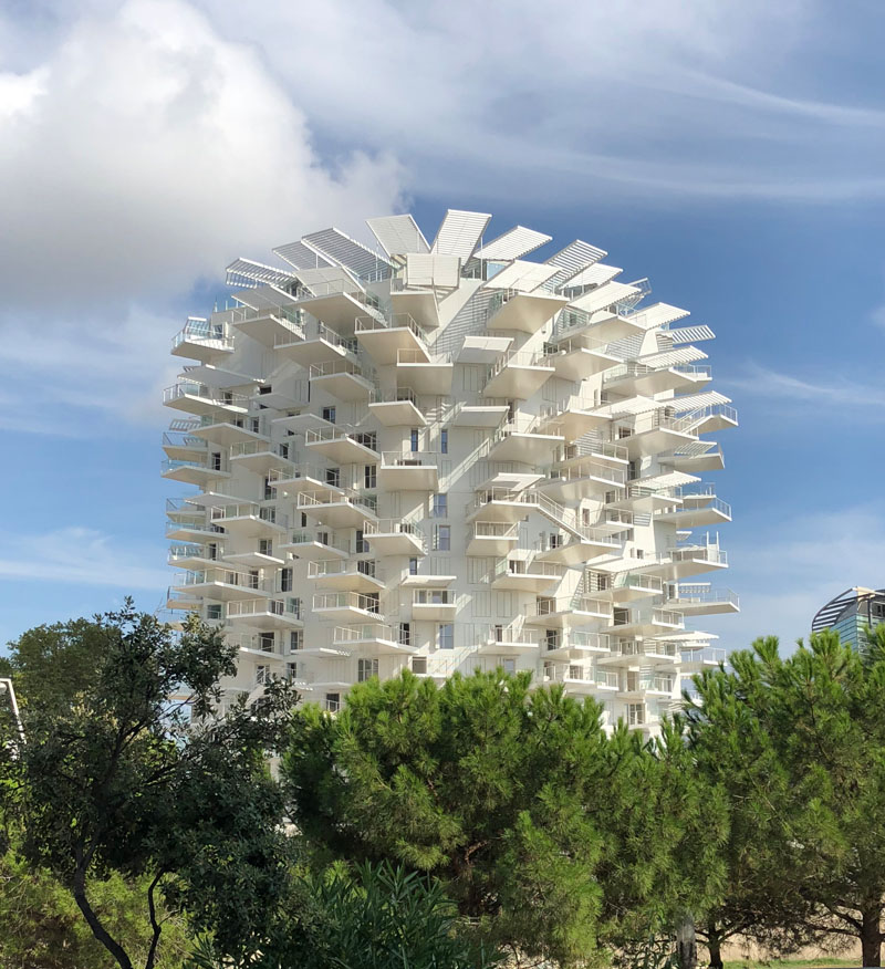 This modern apartment building in France has cantilevered balconies that surround it, while stairs connect the various outdoor spaces. #ModernArchitecture #BuildingDesign #Balconies