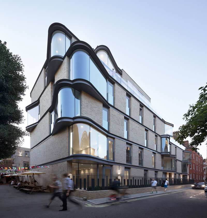 The floor-to-ceiling curved windows protruding from this modern apartment were designed to enlarge the interior living space, while also adding interest to the exterior of the building for people walking past. #Windows #CurvedWindows #ModernArchitecture