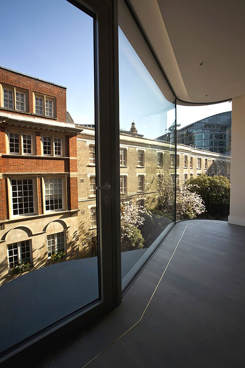 The floor-to-ceiling curved windows protruding from this modern apartment were designed to enlarge the interior living space, while also adding interest to the exterior of the building for people walking past. #Windows #CurvedWindows #ModernArchitecture