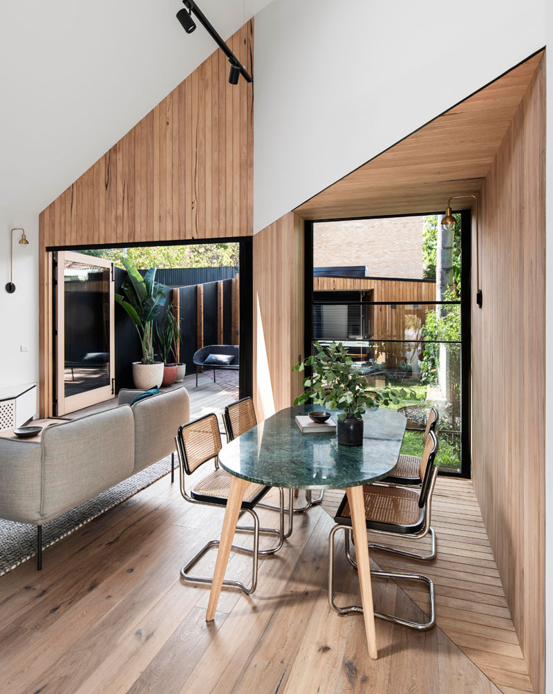 The wood covered walls of this modern house addition highlight the design of the vaulted ceiling, and create a backdrop for the dining table and chairs. #WoodWalls #DiningRoom #VaultedCeiling