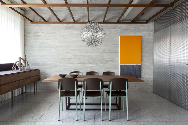 The concrete structure of the building has been left visible in some parts of this modern apartment, like the wall behind the dining area, and the ceiling. #ConcreteWall #PolishedConcreteFloors #ModernApartment