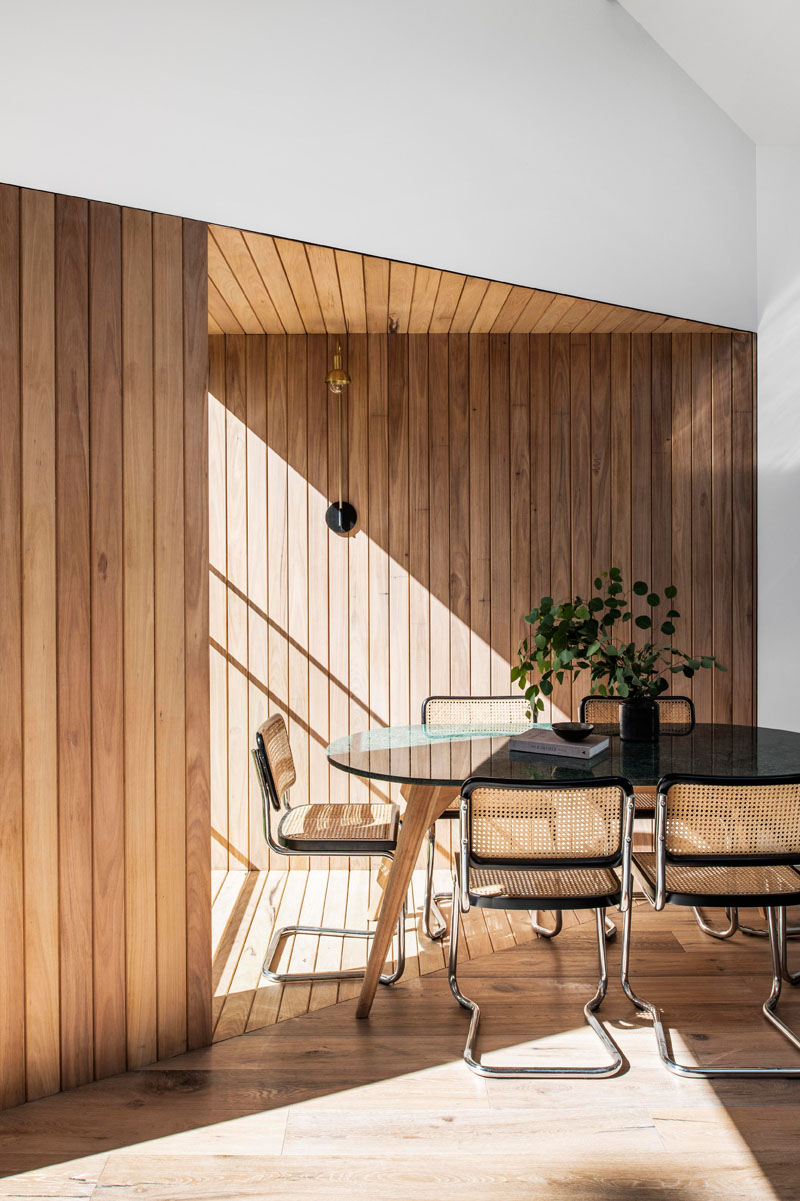 The wood covered walls of this modern house addition highlight the design of the vaulted ceiling, and create a backdrop for the dining table and chairs. #WoodWalls #DiningRoom #VaultedCeiling