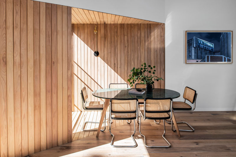The wood covered walls of this modern house addition highlight the design of the vaulted ceiling, and create a backdrop for the dining table and chairs. #WoodWalls #DiningRoom #VaultedCeiling