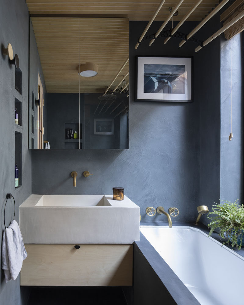 In this modern bathroom, dark grey blue has been used to contrast the wood ceiling. #DarkBlueBathroom #BlueBathroom #ModernBathroom