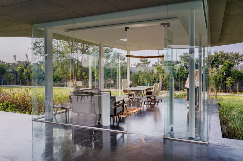 This modern office is surrounded by glass to allow for uninterrupted views of the garden. #GlassWalls #OfficeDesign