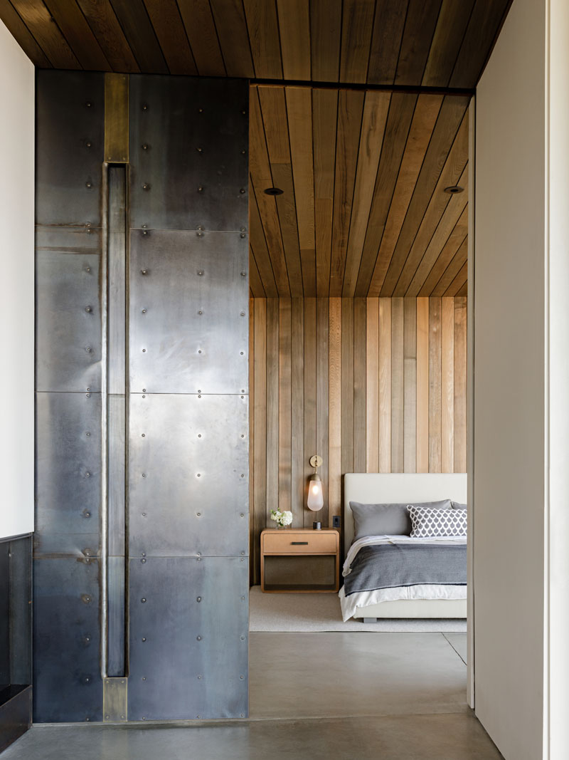 This modern house features a sliding cold-rolled steel plate door that separates the bedroom from the living room. #SteelDoor #ModernInterior