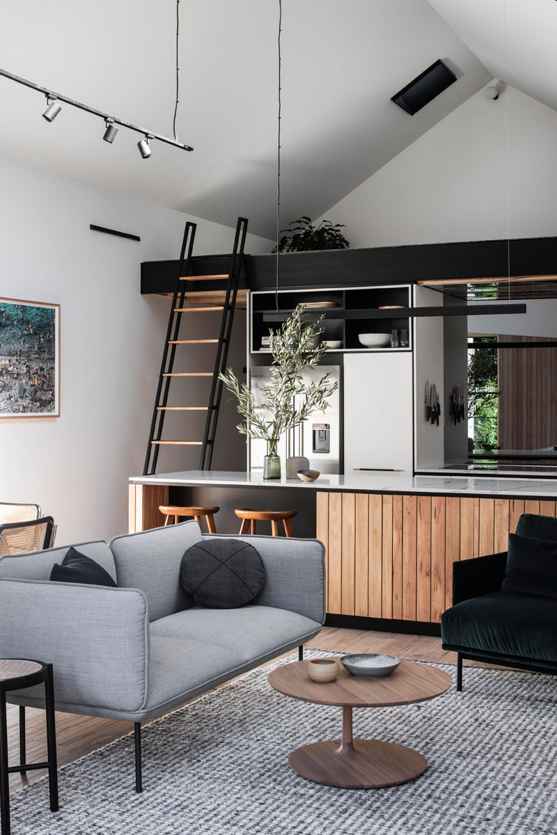 A ladder, that normally hangs on the wall, can be used to gain access to the loft above the kitchen in this modern interior. #Loft #Ladder #ModernInterior