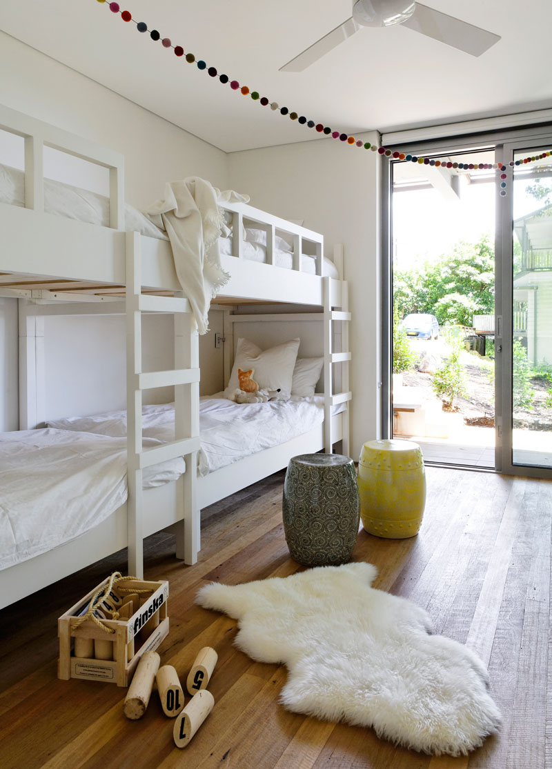 In this kids bedroom, bunk beds have been included to create enough room for four to sleep, and a sliding glass door opens to the garden. #KidsBedroom #BunkBeds