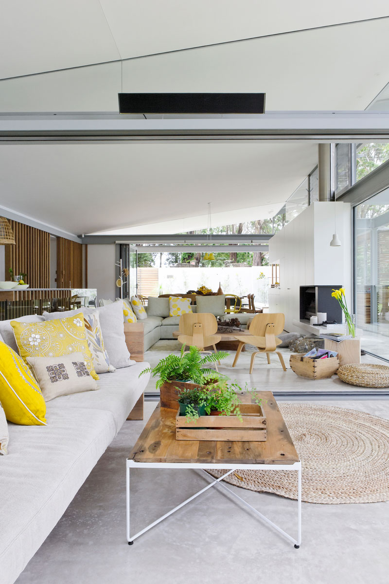 The open plan interior of this modern house has pops of yellow decor to keep the interior bright and welcoming. #YellowDecor #InteriorDesign #ModernInterior #OpenPlan