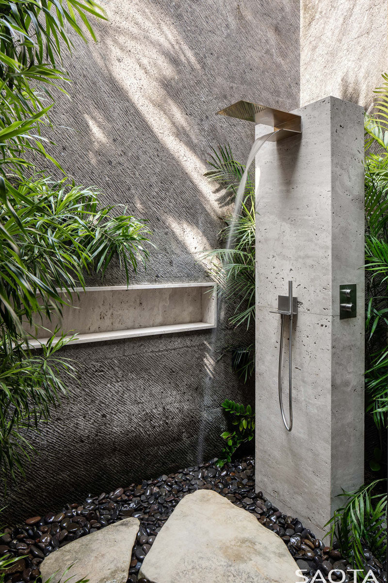 This modern house has an outdoor shower, where a custom shelf has been added to the wall that provides privacy for the user. #OutdoorShower