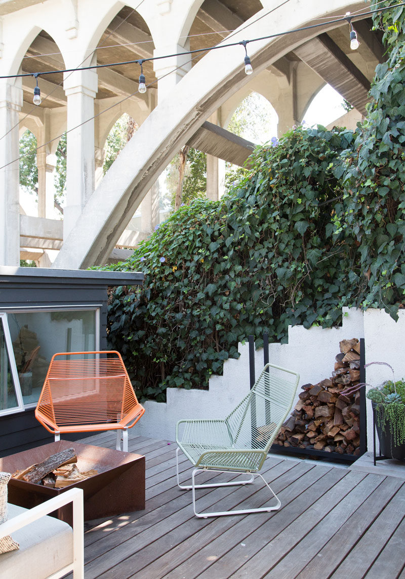 This modern outdoor space with a firepit, is surrounded by plants, and provides a unique perspective of the bridge. #OutdoorSpace #Firepit