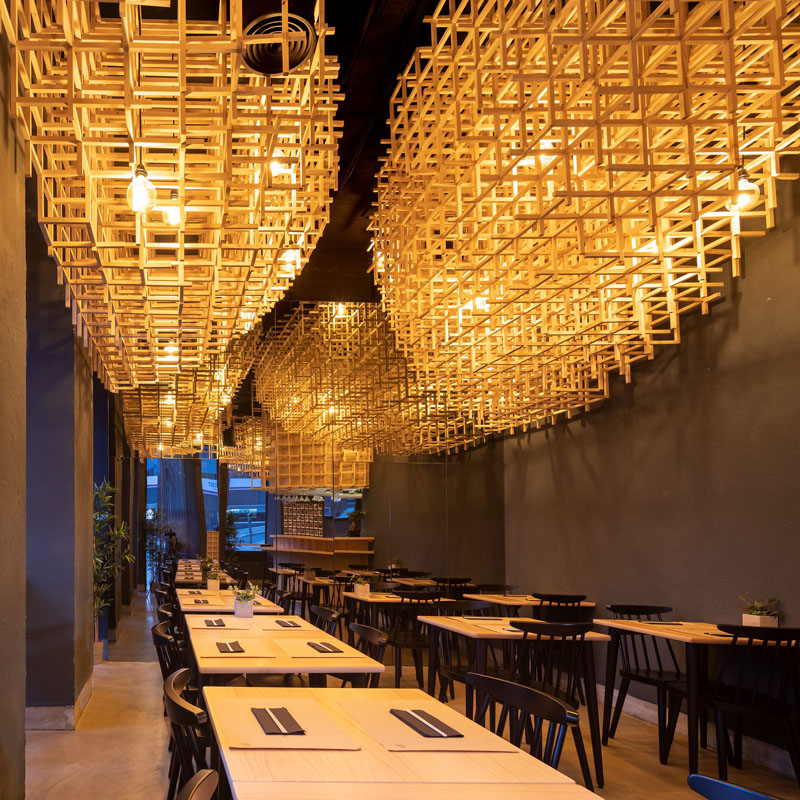 Drawing inspiration from 'Ajitama', the Japanese name for soft-boiled eggs that are usually found in ramen, the designers created sculptural lighting that quickly becomes the focal point of this modern restaurant the minute a guest steps inside. #ModernRestaurant #RestaurantDesign #InteriorDesign #Lighting