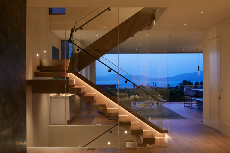 This modern glass-enclosed staircase is illuminated by an oversized operable skylight that is situated in the center of the home, allowing natural light and air to permeate each floor. #ModernStaircase #ModernStairs