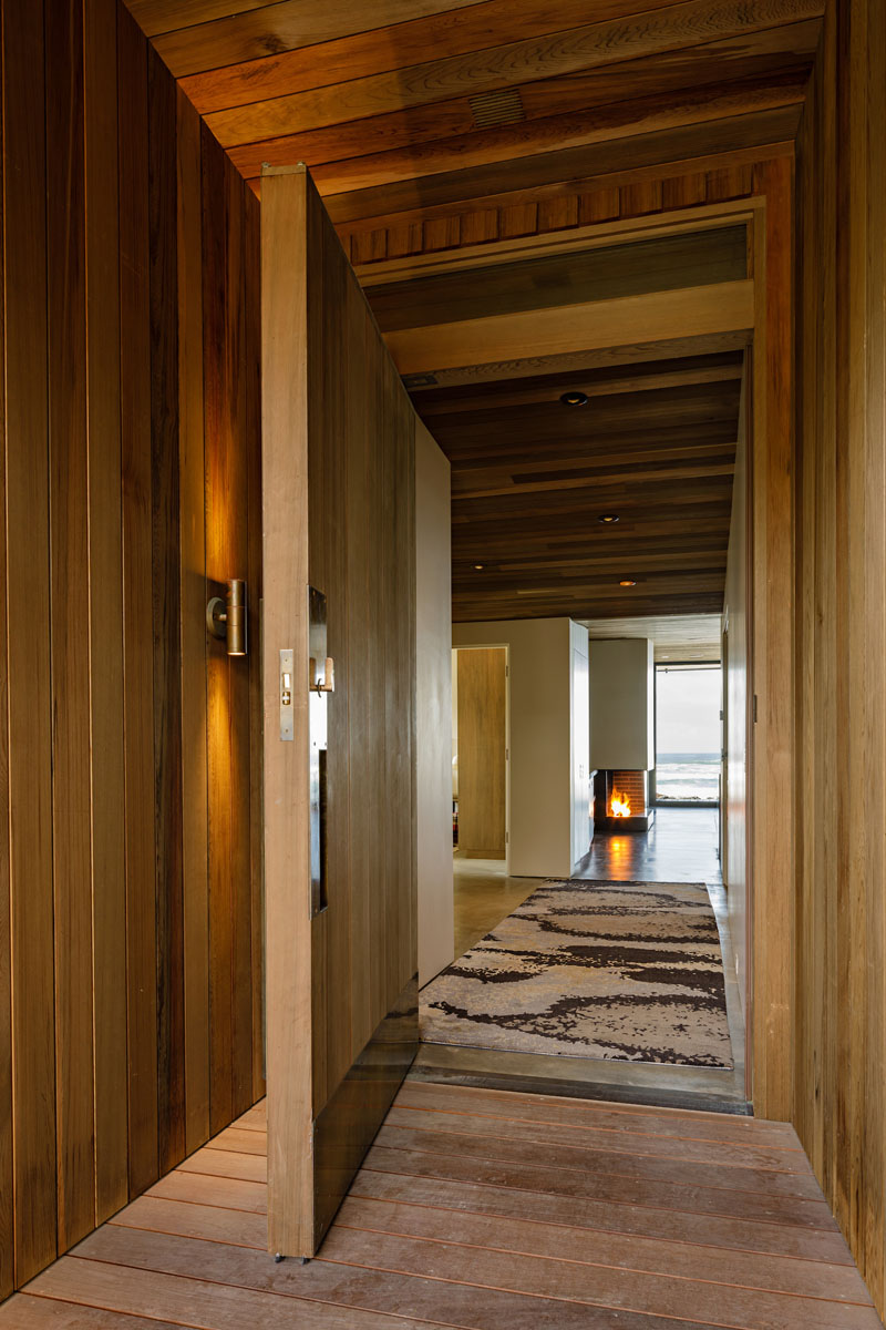 A covered entryway leads to the large front door, which when opened, provides views straight through to the ocean. #FrontDoor #Entryway