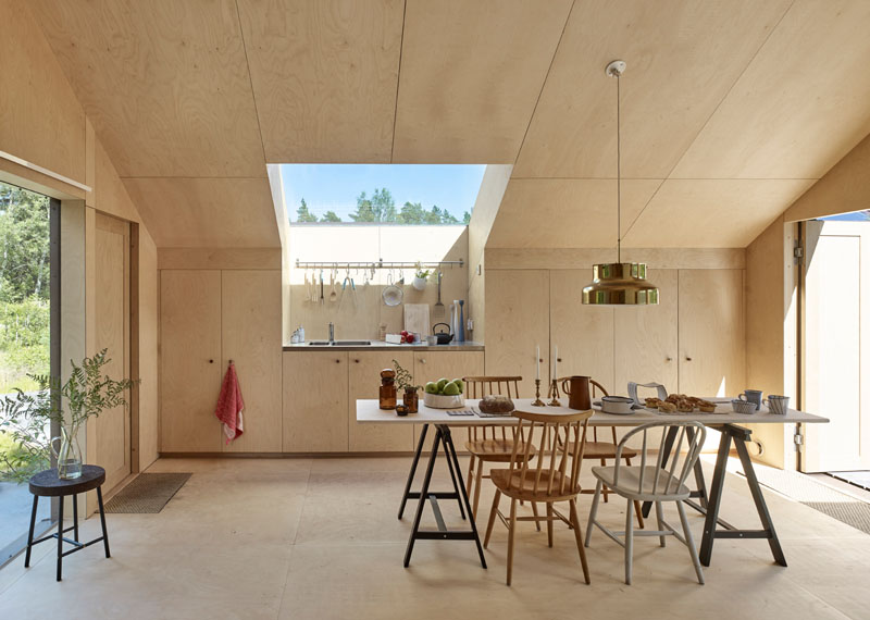 Windows filter the light through to the bright interior of this modern house that features birch plywood walls, ceiling, and floor. #PlywoodWalls #PlywoodInterior #Windows #Kitchen