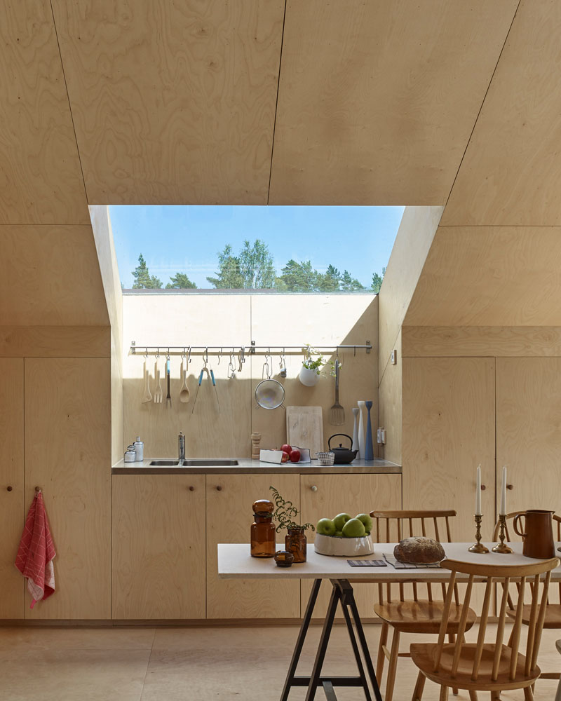 Windows filter the light through to the bright interior of this modern house that features birch plywood walls, ceiling, and floor. #PlywoodWalls #PlywoodInterior #Windows #Kitchen