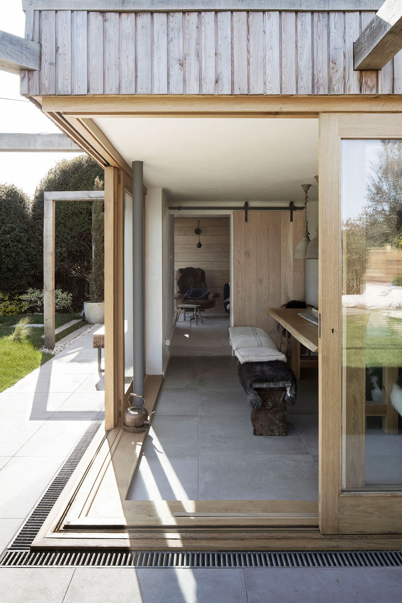 This wood covered addition has sliding wood-framed glass doors that meet at the corner of the dining room, open to the backyard, creating an indoor/outdoor living environment. #SlidingDoors #HouseAddition