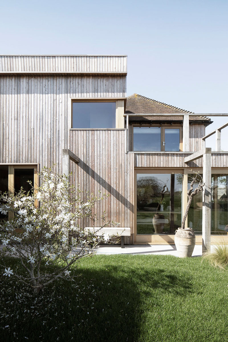 This contemporary house addition is covered in larch, a type of wood siding. #WoodSiding #TimberCladding #WoodExterior #WoodHouse