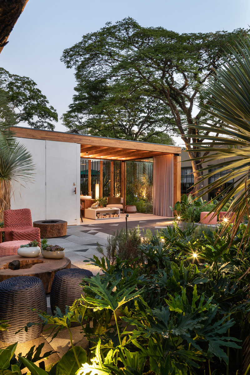 This modern outdoor terrace includes a wooden structure made from Brazilian pinus, wall coverings and flooring made of concrete, a toilet area, waiting lounge, and a counter with basins and a fireplace. #OutdoorTerrace #Terrace #Architecture #OutdoorSpace