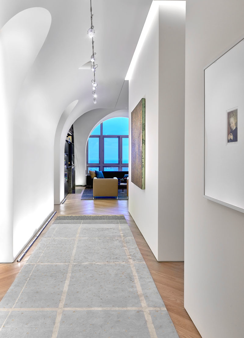 Arches in this modern penthouse offer dramatic space for the owner’s art collection and temper the impact of 14-foot ceilings. #Arches #Architecture #Hallway #VaultedCeiling #HighCeilings