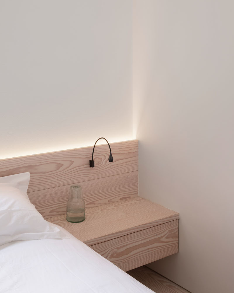 Bedroom Ideas - This simply finished modern bedroom features flush faced built-in hanging cupboards, bespoke Douglas fir bedside cabinetry, and hidden lighting that creates a calm atmosphere. #bedroomIdeas #WoodHeadboard #ModernBedroom #HiddenLighting