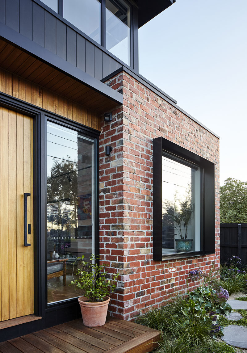 Surrounded by the recycled bricks is a deep steel window box detail that adds depth and shadow to this modern house facade. #Window #Bricks #ModernHouse