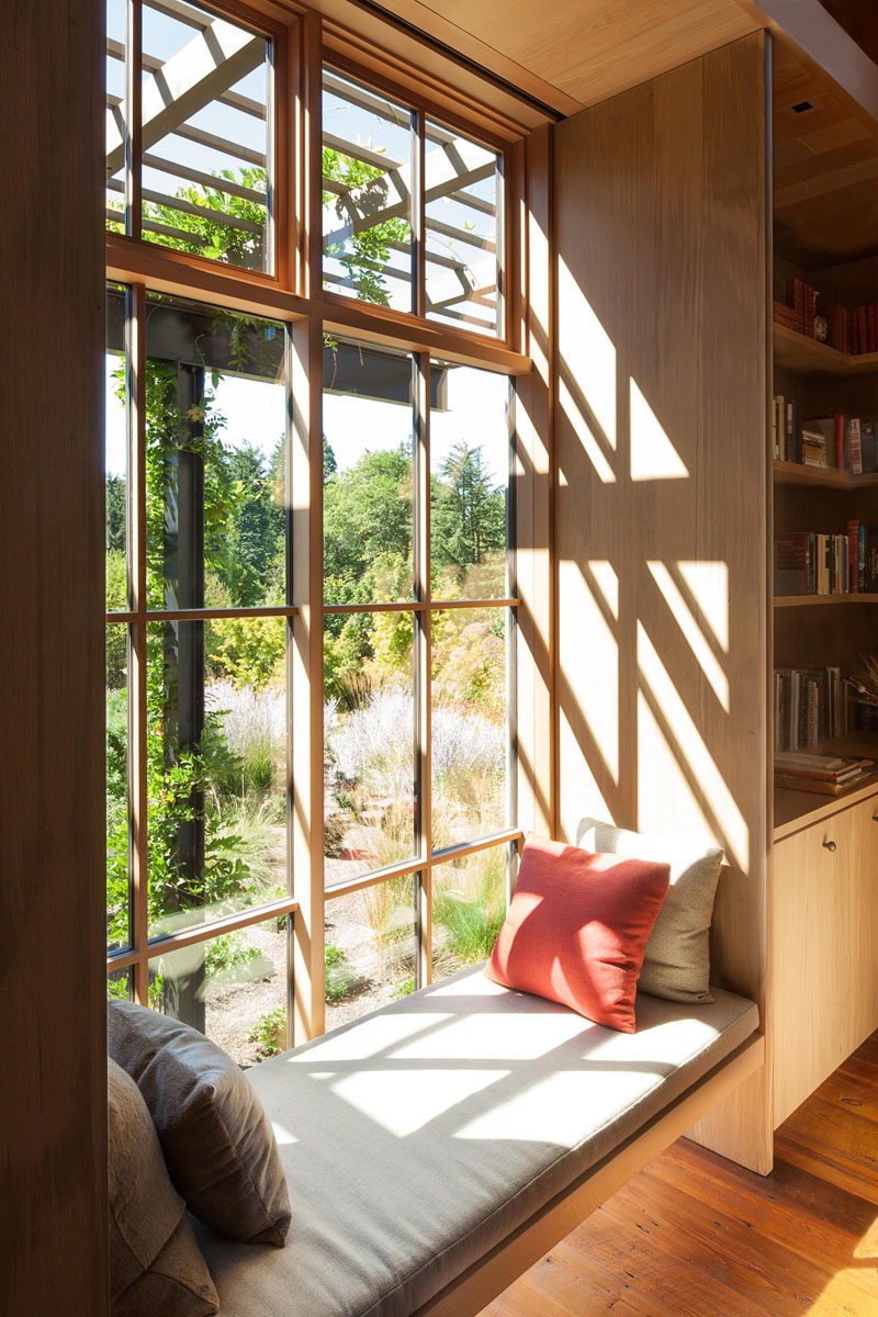 Window Seat Ideas - In this den, built-in bookshelves line the walls, while a window seat provides a place to quietly read and enjoy the views outside. #WindowSeat #Seating #Den #Bookshelves