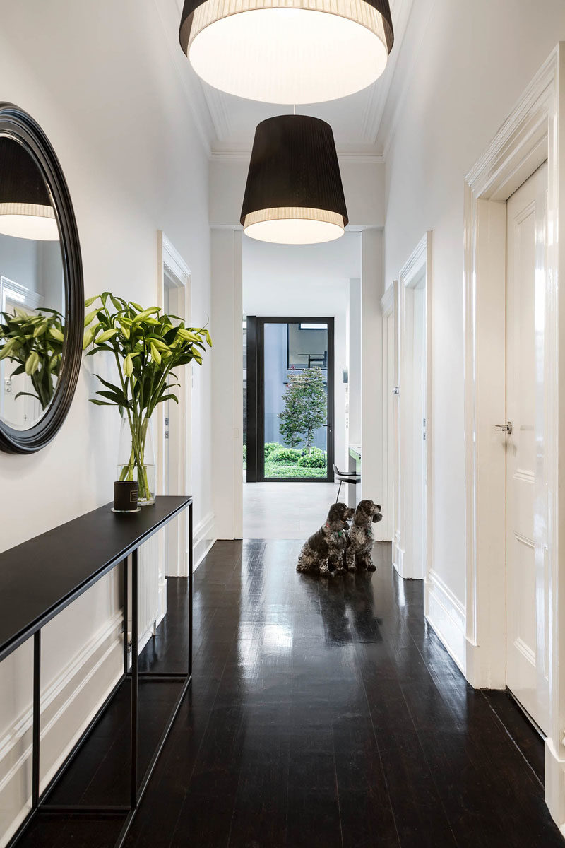 Hallway Ideas - Sight lines were introduced to capture the views of the pool and garden from the key areas of the home, like in the hallway that's brightened with the use of two pendant lamps. #Hallway #InteriorDesign #HallwayIdeas