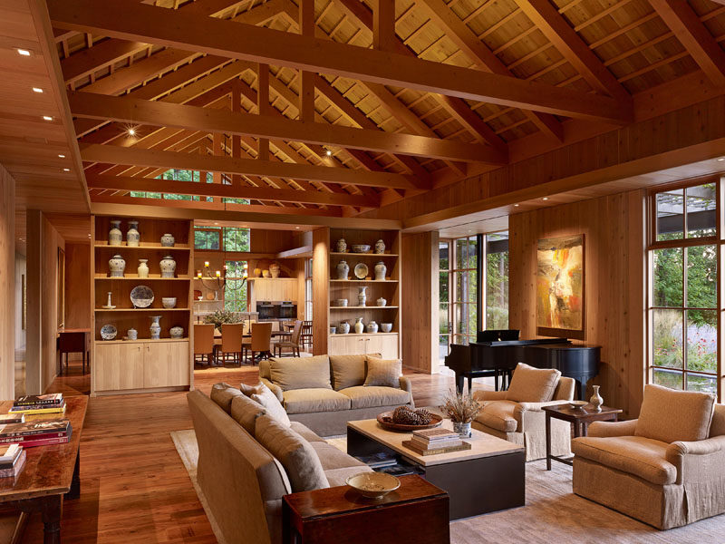 Living Room Ideas - Built-in shelves and cabinets show off a collection of porcelain, while the exposed wood ceiling draws the eye upwards, and the windows fill the room with natural light. #LivingRoom #ExposedCeiling #CustomCasework #Windows